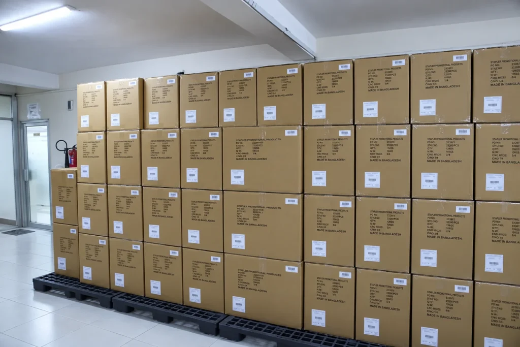 Labeled cartons stacked on pallets in the Wenext Caps factory packing area